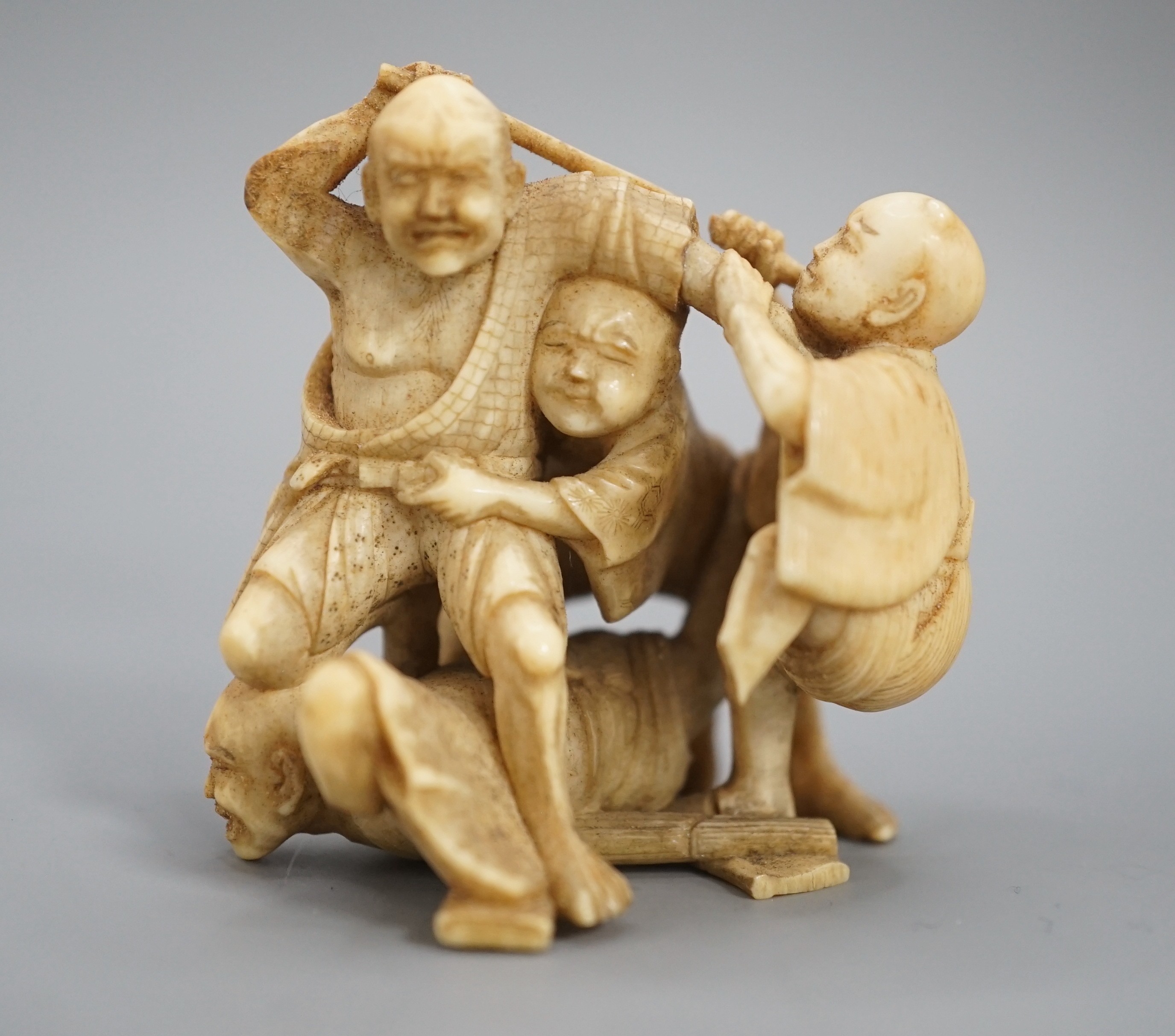 A Japanese ivory group of four men fighting, signed, Meiji period, 5.5cm